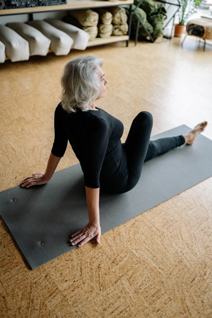 Mature woman doing a pelvic floor and core stretch on a yoga mat at home